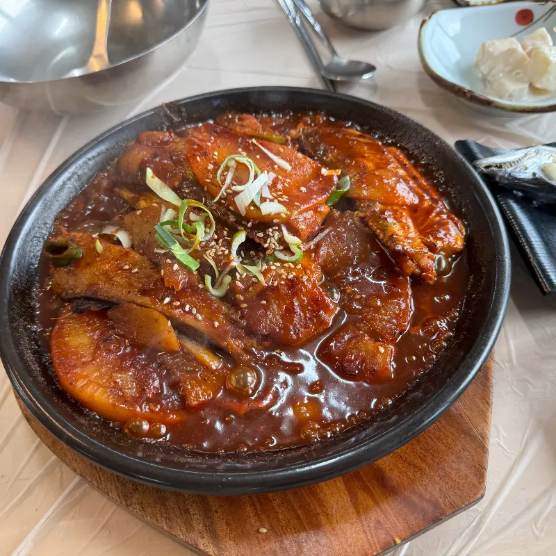 갈치구이 한 점이 젓가락에 들려 있다.