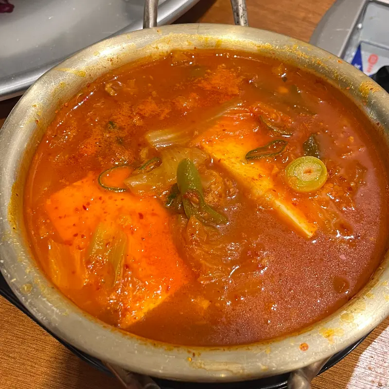 김치찌개가 뚝배기에 담겨 보글보글 끓고 있는 모습