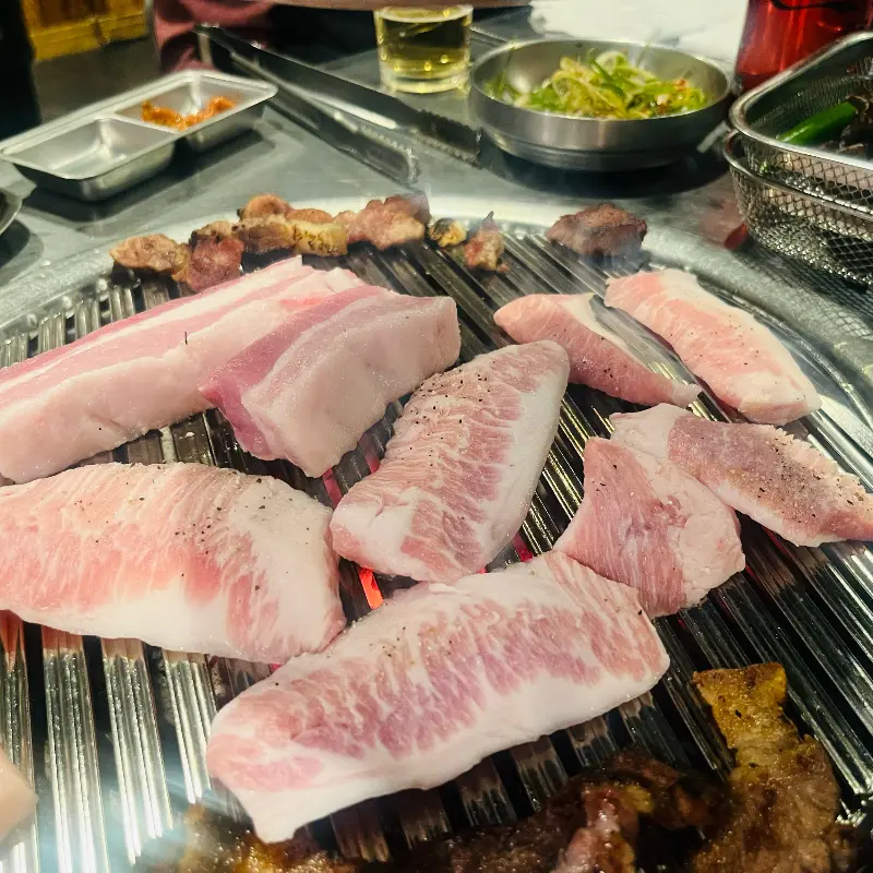 불판 위에서 노릇하게 익어가는 흑돼지