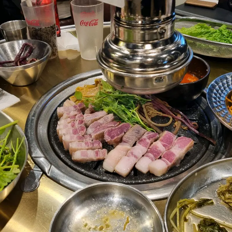 숯불 위에서 익어가는 흑돼지 오겹살과 목살