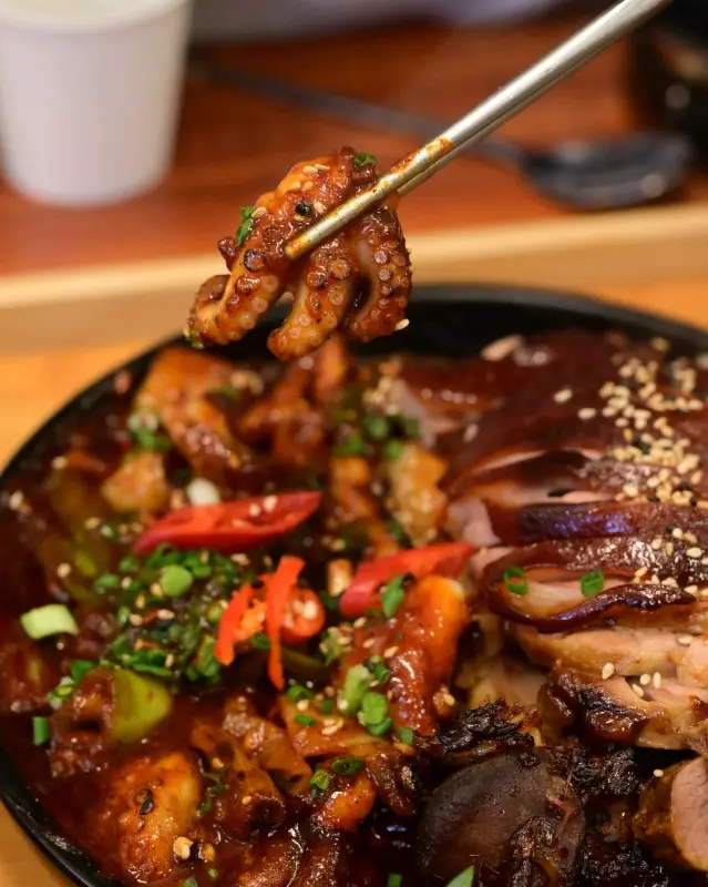 젓가락으로 쭈꾸미를 집어 올리는 모습이 담겨 있다.