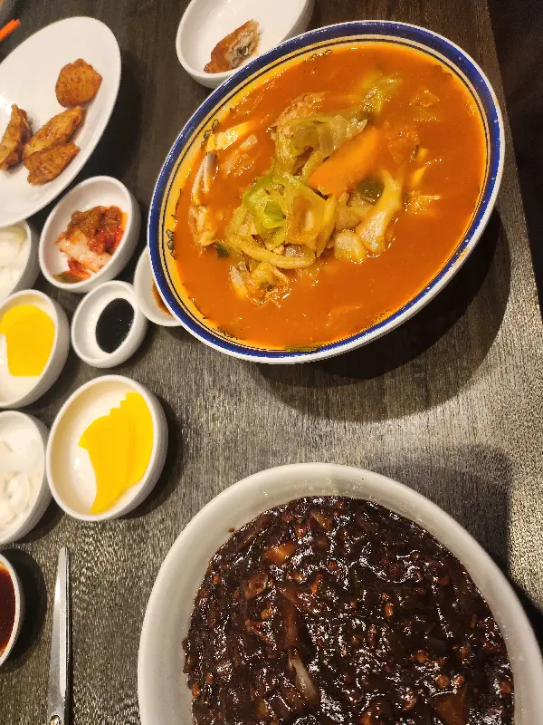 짜장면, 꽃게짬뽕, 야끼만두가 놓인 테이블 사진