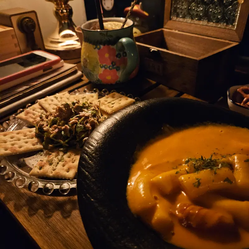 테이블 위에 놓인 로제 떡볶이와 크래커 안주