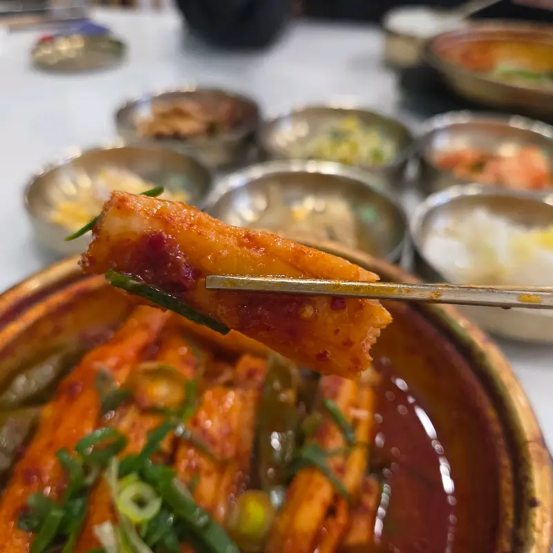 젓가락으로 갈치조림을 들어올리는 모습