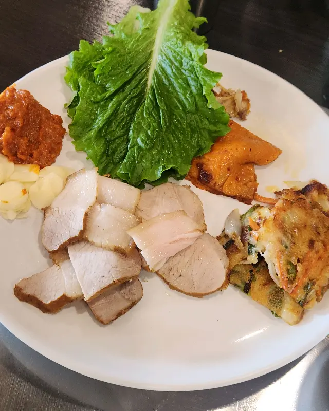 돔베고기와 다양한 반찬을 담은 접시