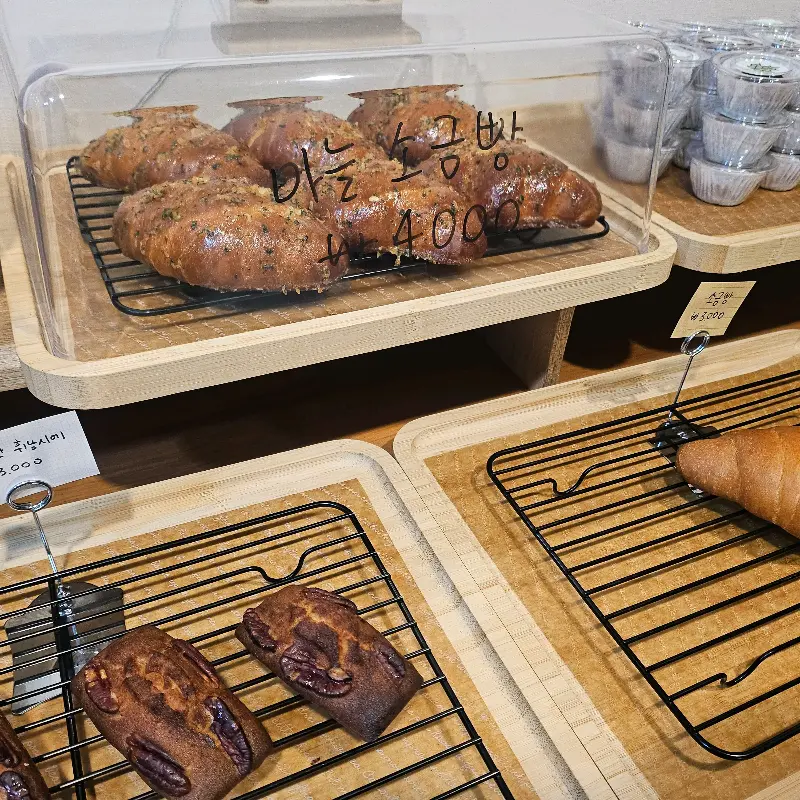 먹음직스러운 소금빵과 다른 빵들이 진열된 모습