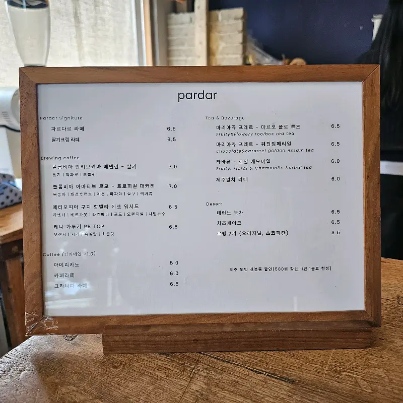 돌담과 푸른 식물이 어우러진 카페 외관