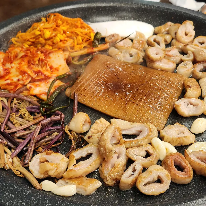 불판 위에 껍데기와 막창, 김치 등이 올려져 있는 모습