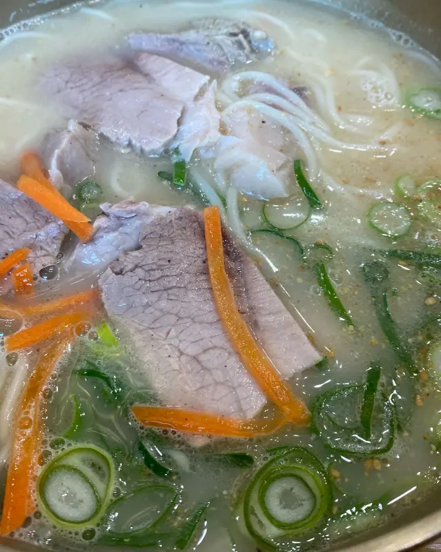 고기 국수 위에는 잘게 썰린 파와 당근이 고명으로 올려져 있다.