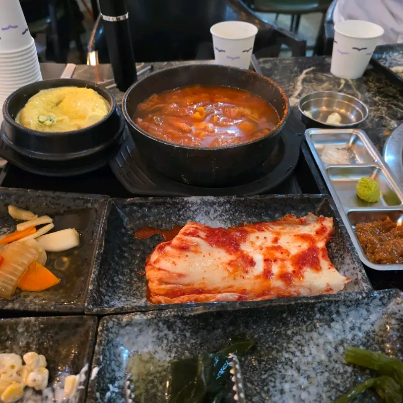 흑돼지와 함께 구워먹는 멜젓, 김치, 콩나물, 고사리의 모습