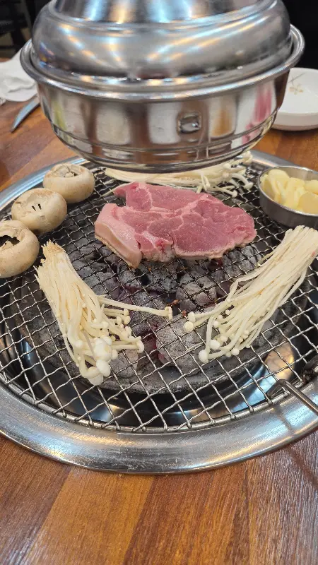 불판 위에 올려진 고기와 버섯