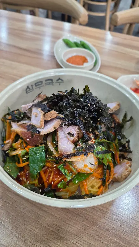 김가루와 깨가 듬뿍 뿌려진 비빔국수의 모습