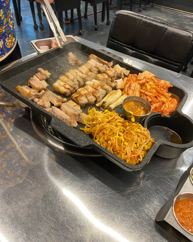 흑돼지 오겹살, 김치, 콩나물 등이 올려진 불판