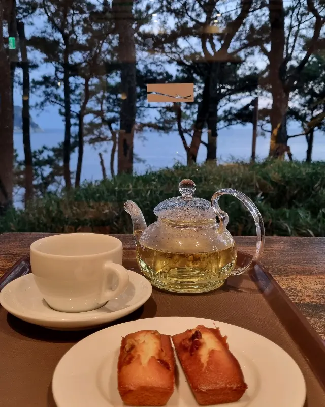 따뜻한 차와 마들렌이 놓여있는 테이블