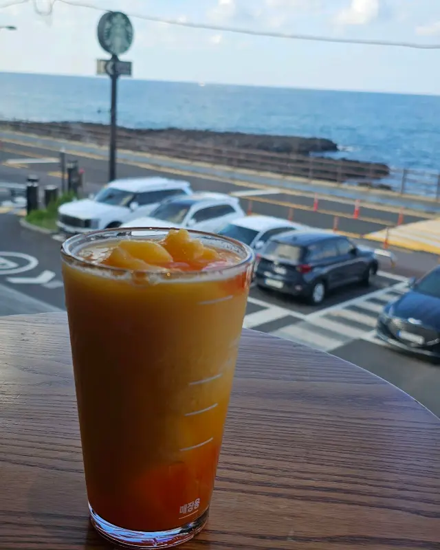 음료와 함께 보이는 제주 바다
