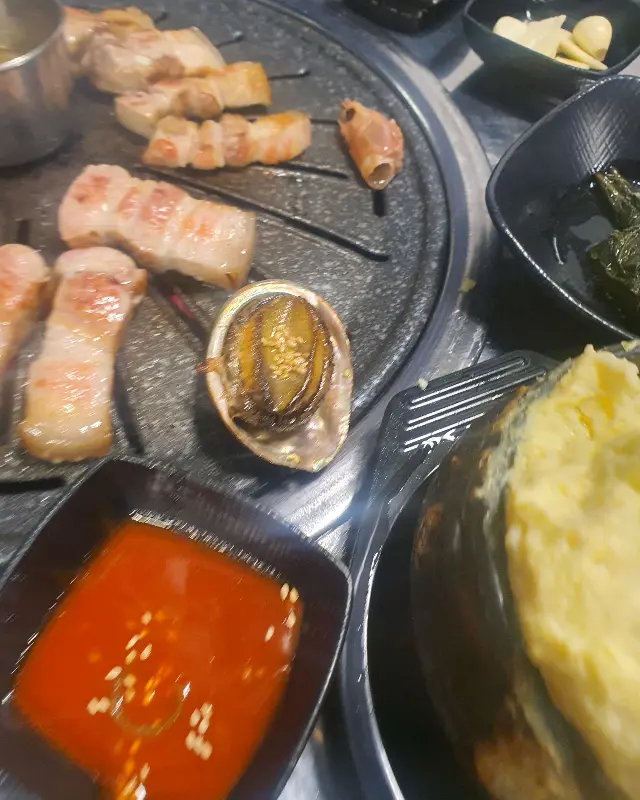 숯불 위에서 구워지는 흑돼지와 전복