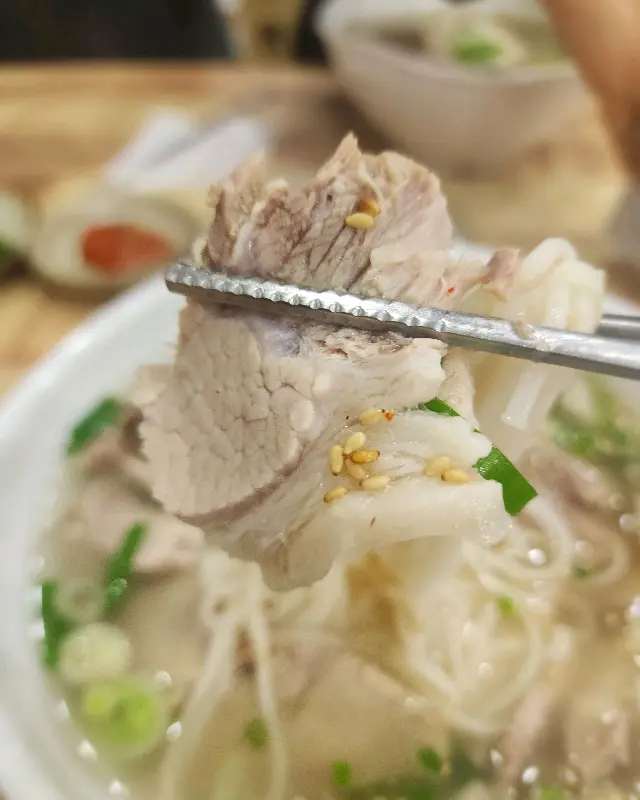 젓가락으로 집어 올린 두툼한 고기 한 점