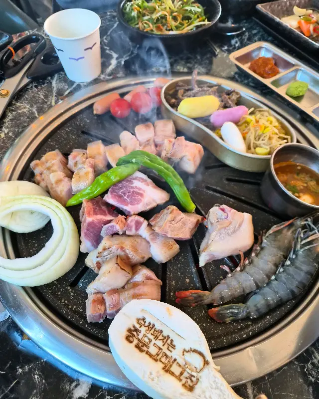 숯불 위에서 맛있게 익어가는 흑돼지 오겹살과 새우