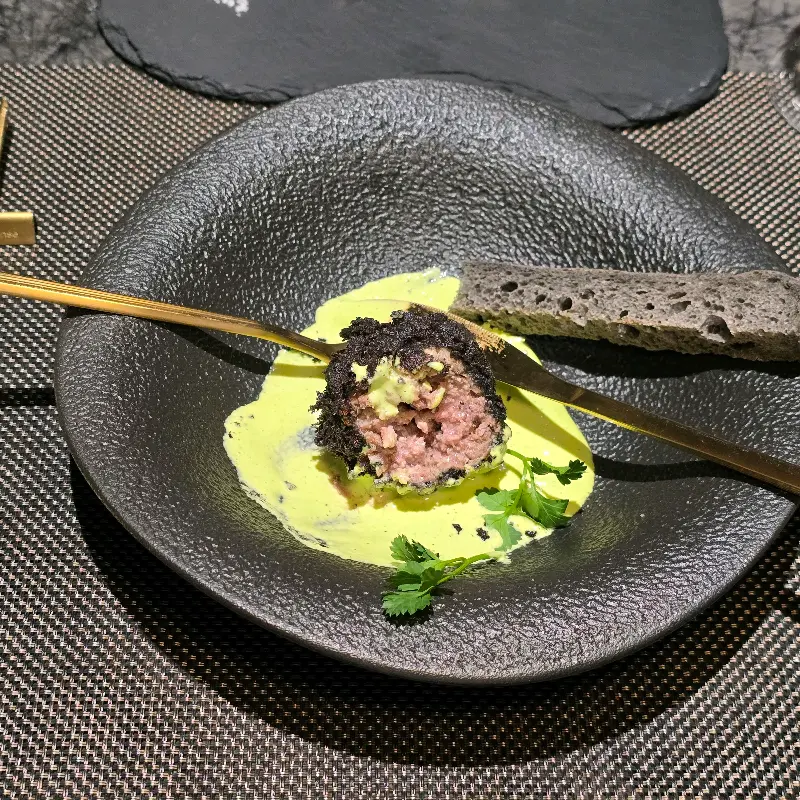 검은 접시에 담겨 나온 현무암 커틀렛