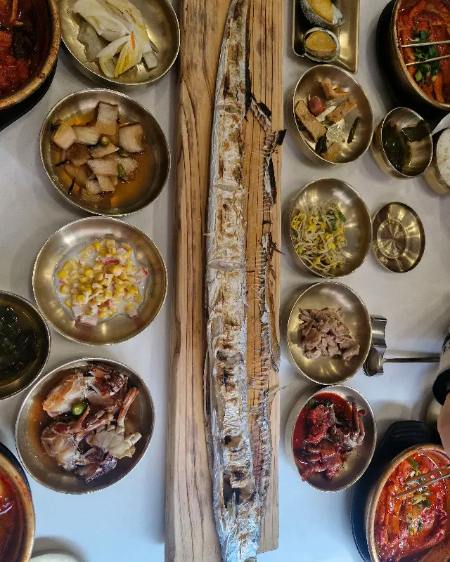 갈치구이 한 마리가 통째로 나무 도마 위에 놓여 있는 모습