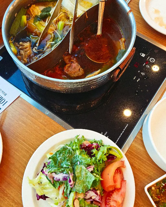 두 가지 육수가 담긴 냄비와 샐러드