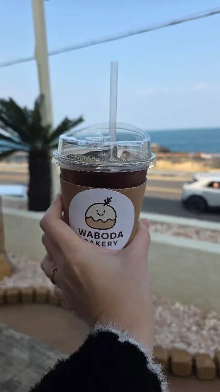 푸른 바다를 배경으로 들고 있는 와보다 커피