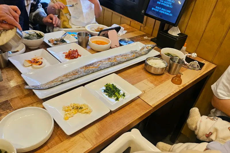 착한집 테이블 전체 샷. 다양한 밑반찬과 메인 메뉴가 가득 차려져 있다.