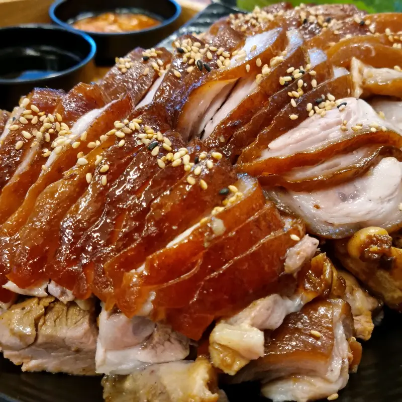 윤기가 흐르는 족발 위에 깨가 뿌려져 있다.