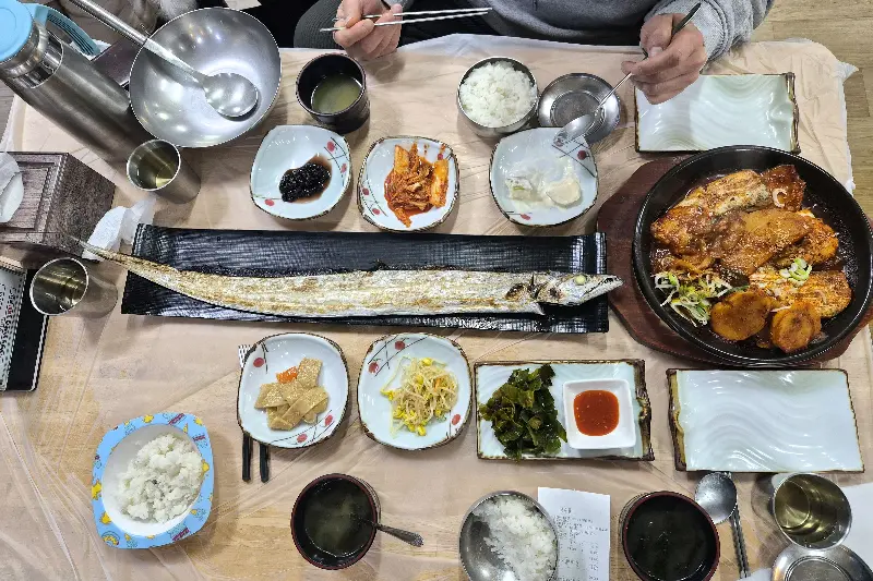 갈치구이와 조림, 푸짐한 밑반찬이 차려진 식탁