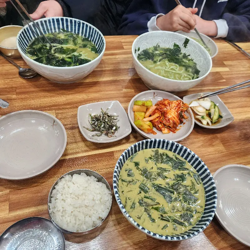 테이블 위 놓인 보말칼국수와 깍두기, 김치