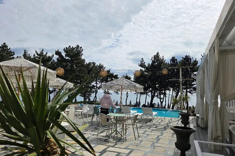 야외 좌석과 수영장, 그리고 멀리 보이는 바다