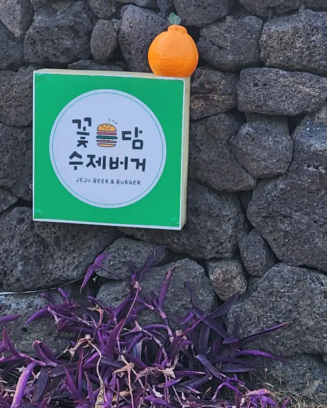 돌담 위에 놓인 꽃담수제버거 간판