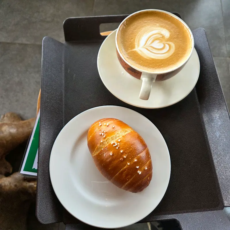 쟁반 위에 놓인 라떼와 소금빵
