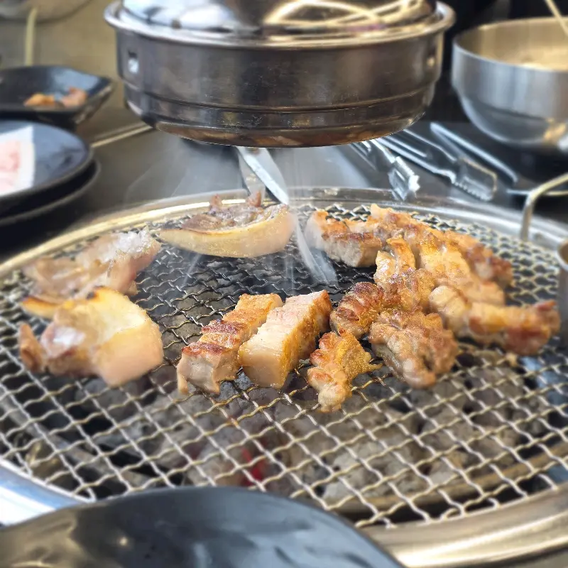 숯불 위에서 노릇하게 익어가는 흑돼지 오겹살