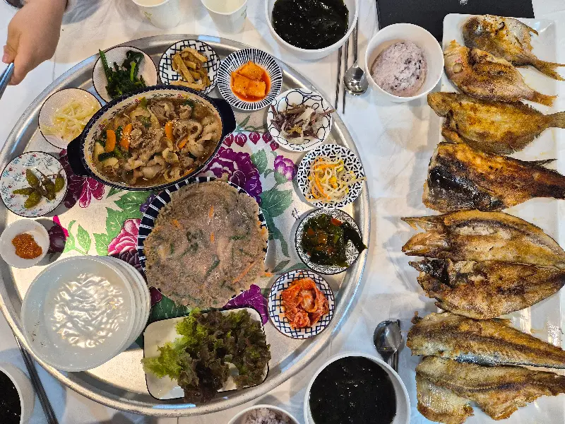 상 위에서 생선구이와 다양한 반찬들이 옹기종기 모여있는 모습