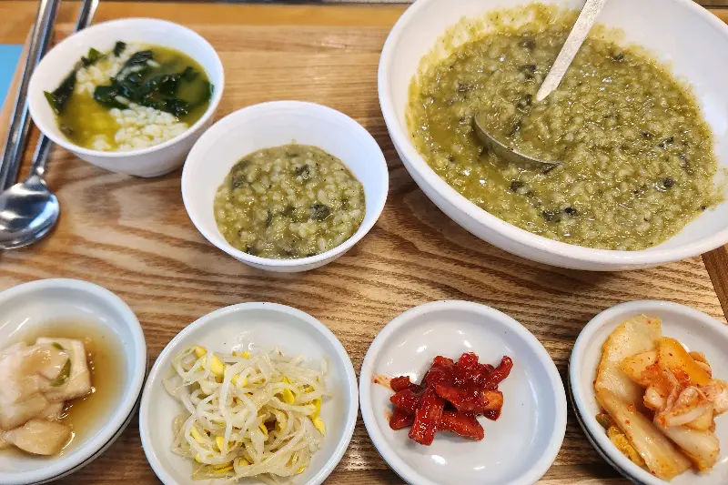 쟁반 위에 놓인 보말죽 한 상 차림, 보말미역국이 함께 제공된다.