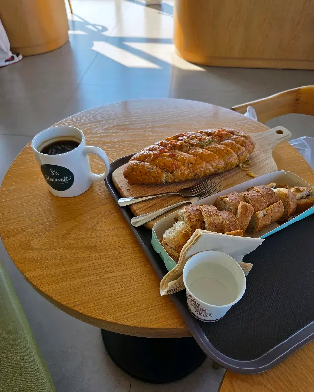 테이블 위에 놓인 아메리카노와 마늘 바게트