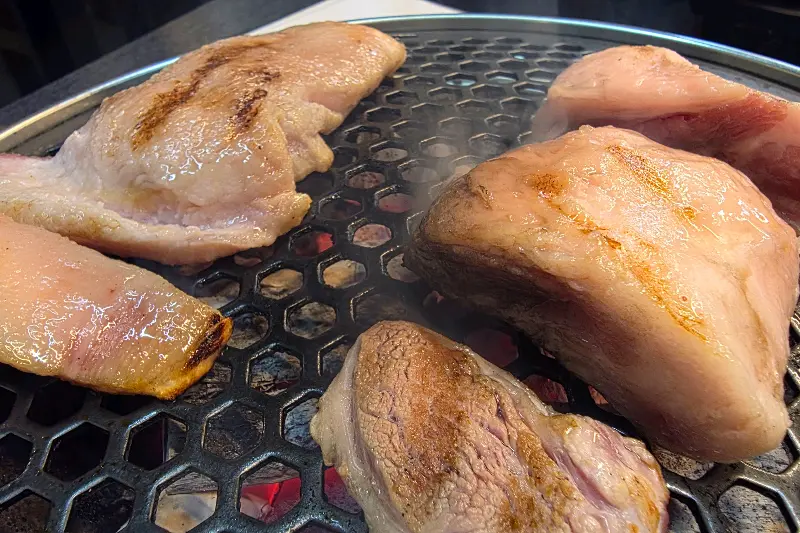 숯불 위에서 노릇하게 구워지고 있는 흑돼지 근고기