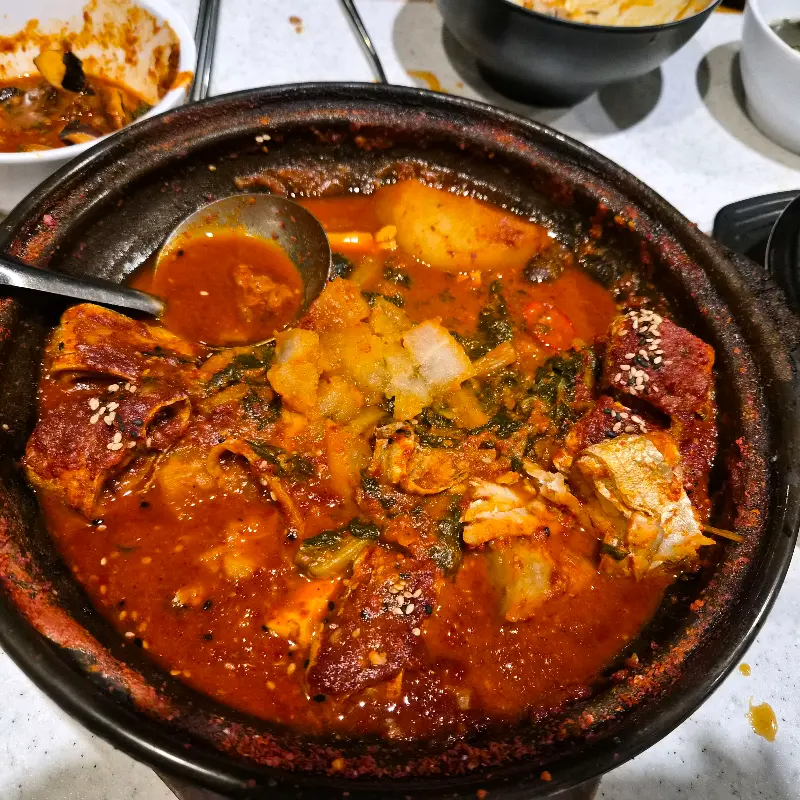 갈치조림을 숟가락으로 떠올린 모습. 큼지막한 갈치와 무, 시래기가 듬뿍 들어있다.