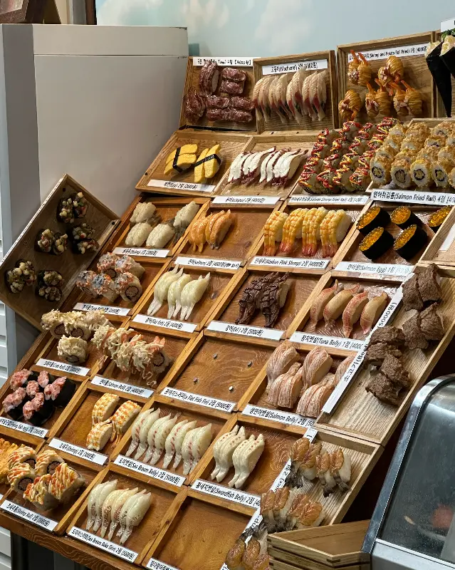 다양한 종류의 초밥 모형이 진열된 모습