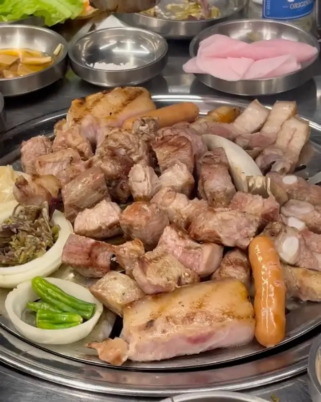 잘 구워진 흑돼지 오겹살과 곁들임 찬