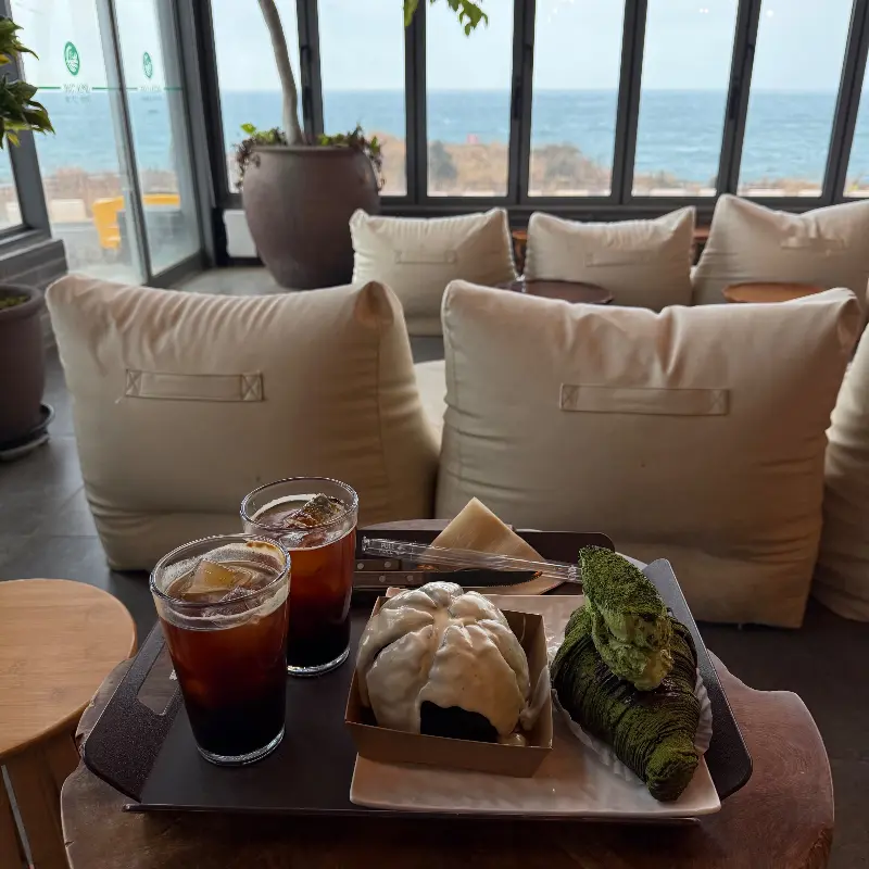 테이블 위에 놓인 음료와 빵, 그리고 빈백 소파가 편안함을 더하는 사진