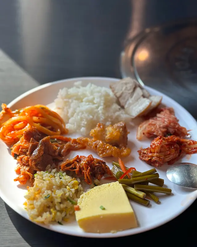 다양한 반찬과 돔베고기, 밥이 담긴 접시