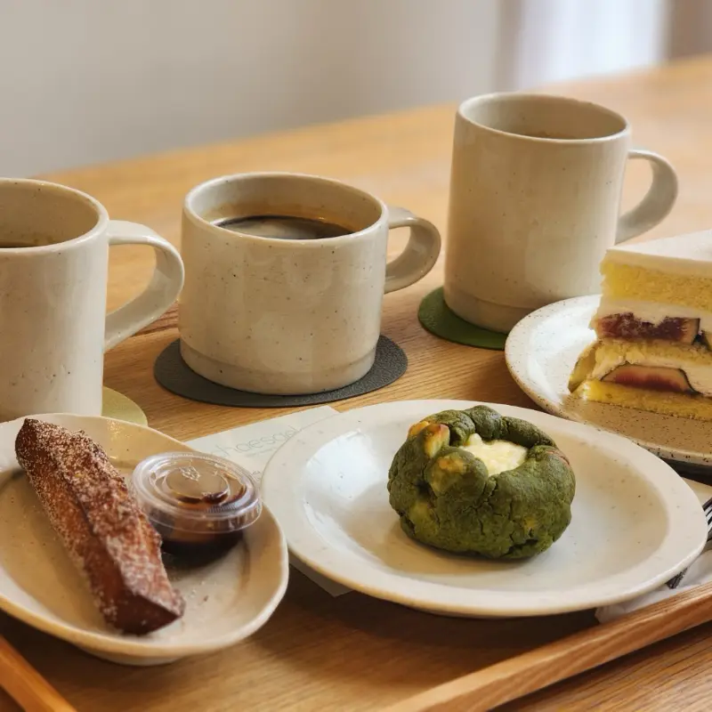 나무 쟁반 위에 놓인 다양한 디저트와 커피