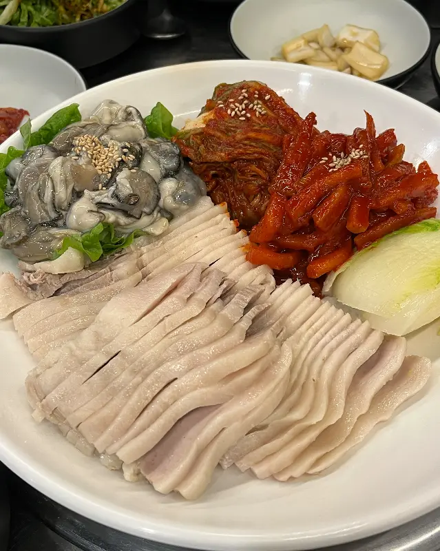 윤기가 흐르는 가브리보쌈과 신선한 굴, 매콤한 김치의 조화