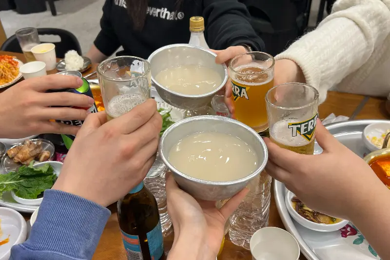 여러 사람이 술잔을 들고 건배하는 모습