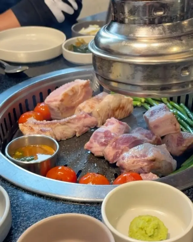 불판 위에 가지런히 놓인 흑돼지 오겹살