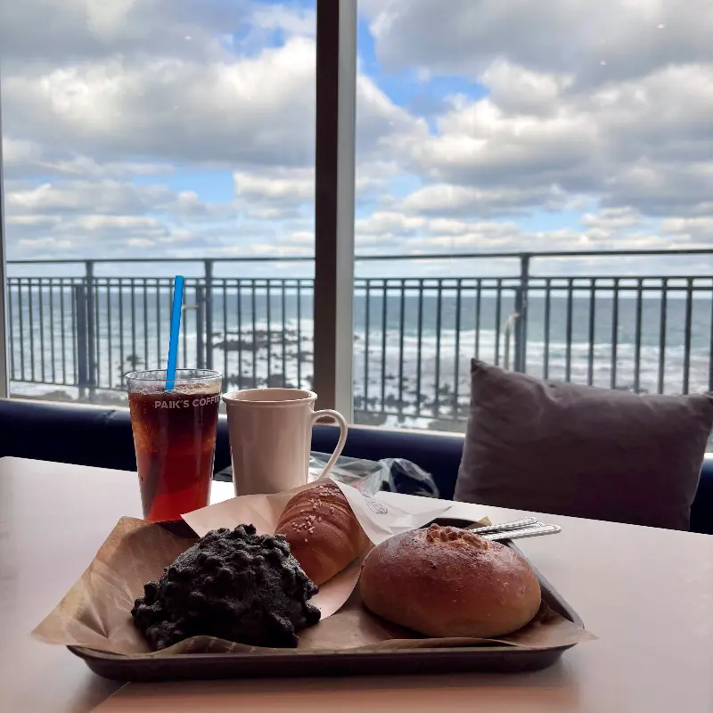 음료와 빵이 놓인 테이블과 창밖 풍경