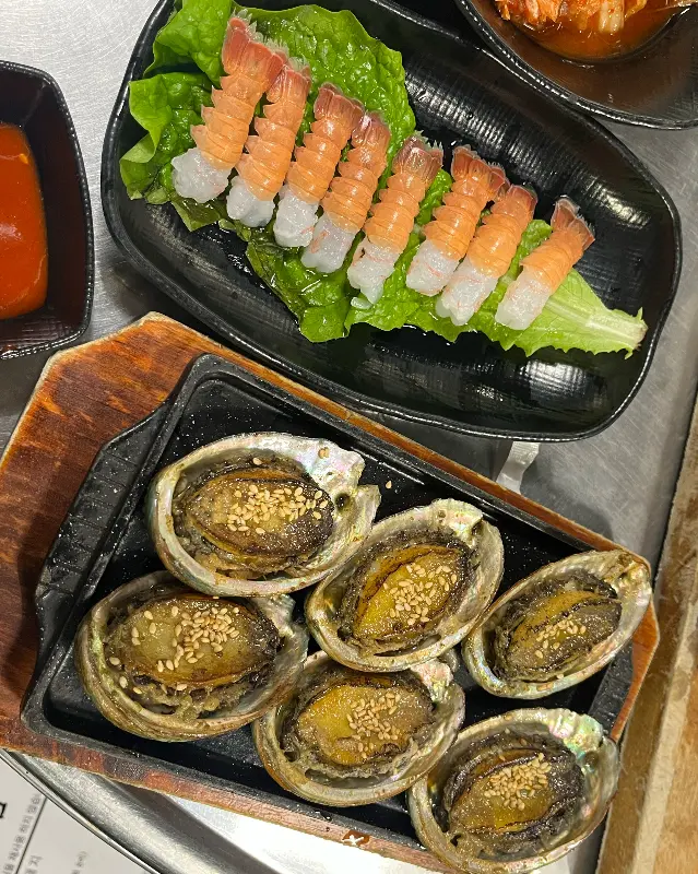 접시에 담긴 구운 전복과 딱새우