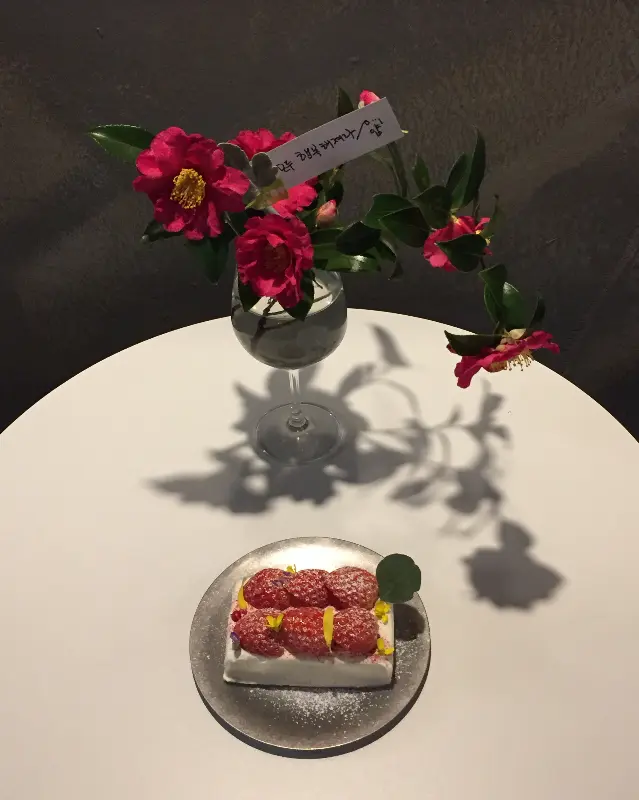 카페 내부: 테이블과 의자, 앤틱 가구, 꽃으로 꾸며져 있다.